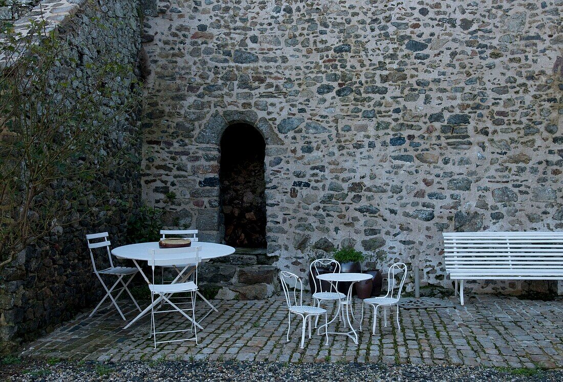 Tisch und Stühle im Freien im Hinterhof eines alten Herrenhauses