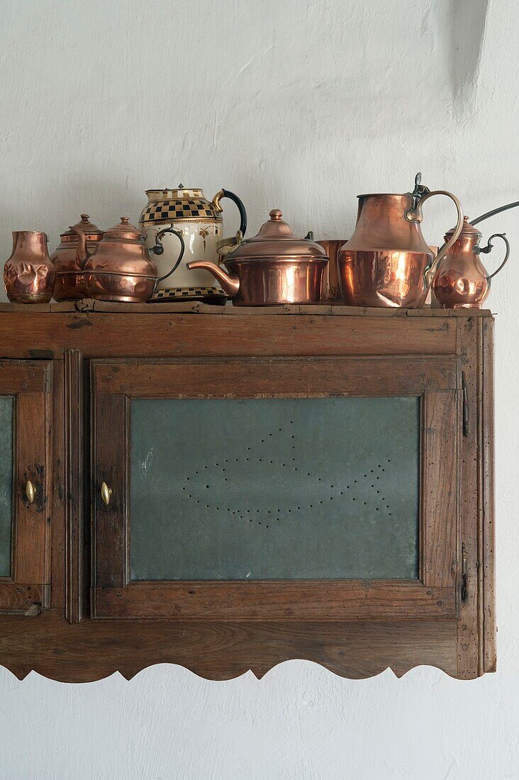 Sammlung antiker Kaffeekannen aus Kupfer auf einem Küchenschrank