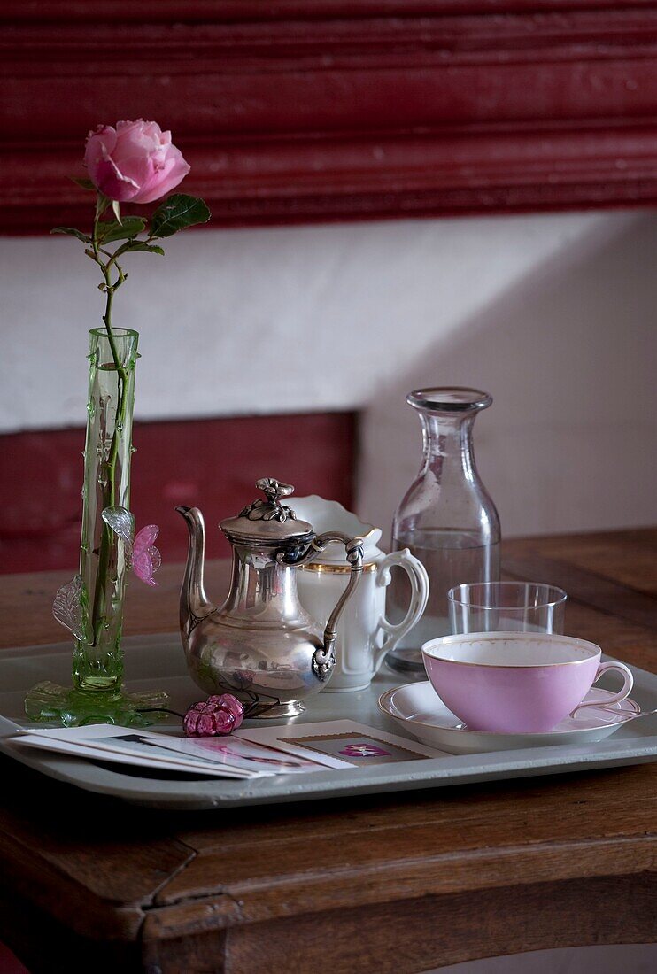 Stillleben mit rosa Rosentasse und Kaffeekanne