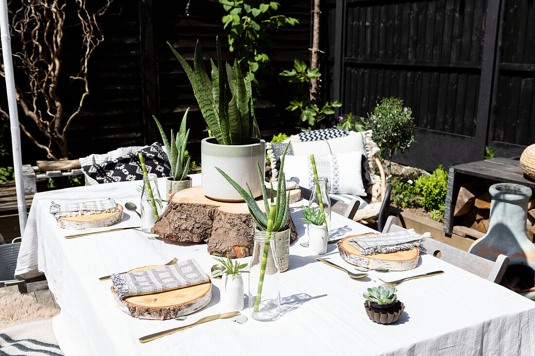 Log discs as place mats with bronze cutlery on table in Colchester garden Essex UK