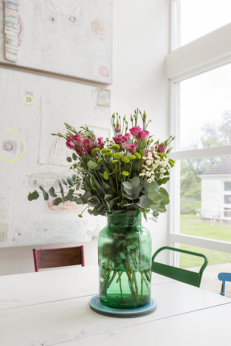 Large vase of cut flowers in double height dining area of Guildford home Surrey UK