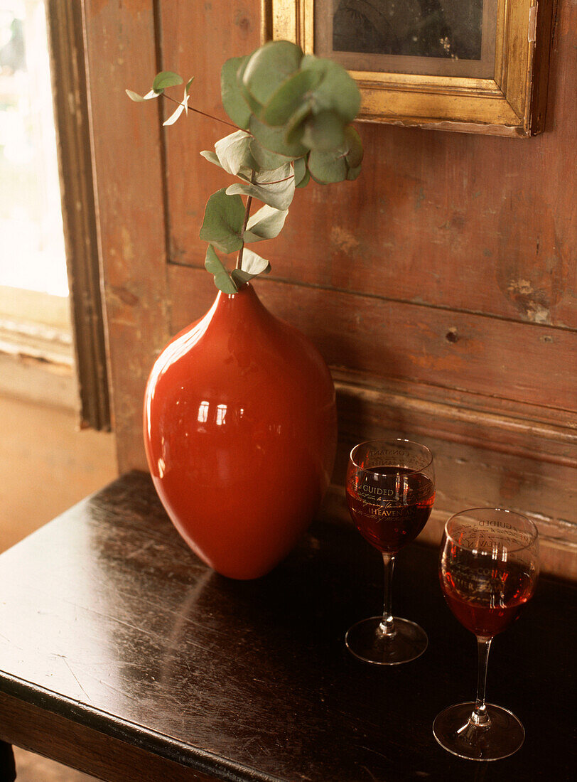 Vase and drinks placed on a side table in wood paneled room