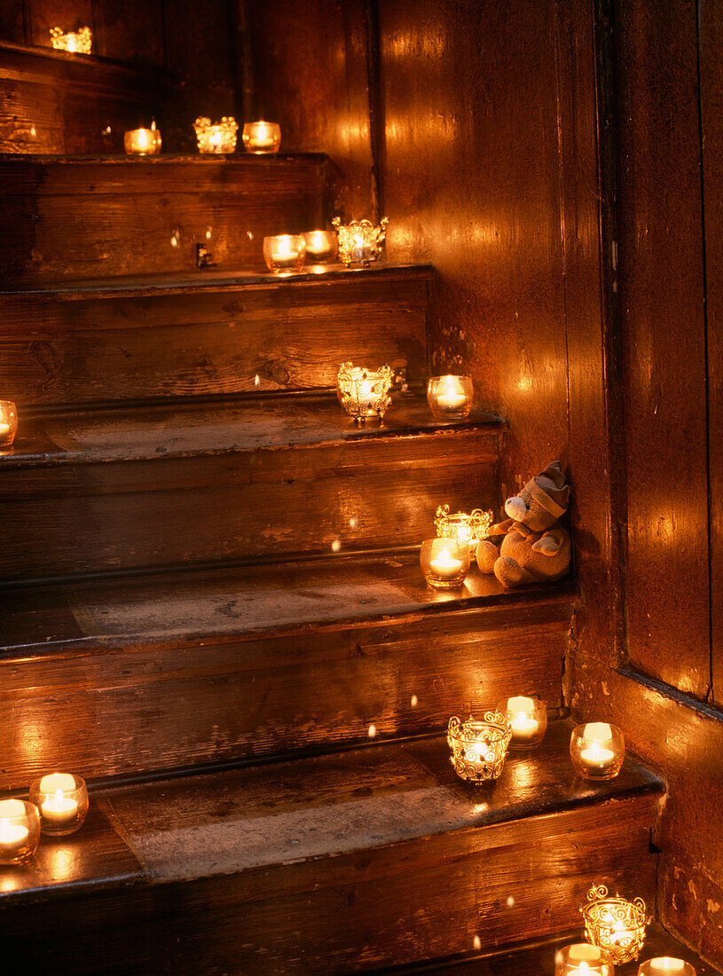 Wooden staircase decorated in lit candle display