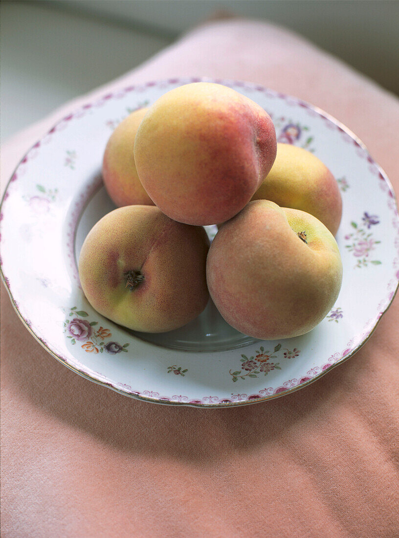 Frische Pfirsiche auf einem gemusterten Teller