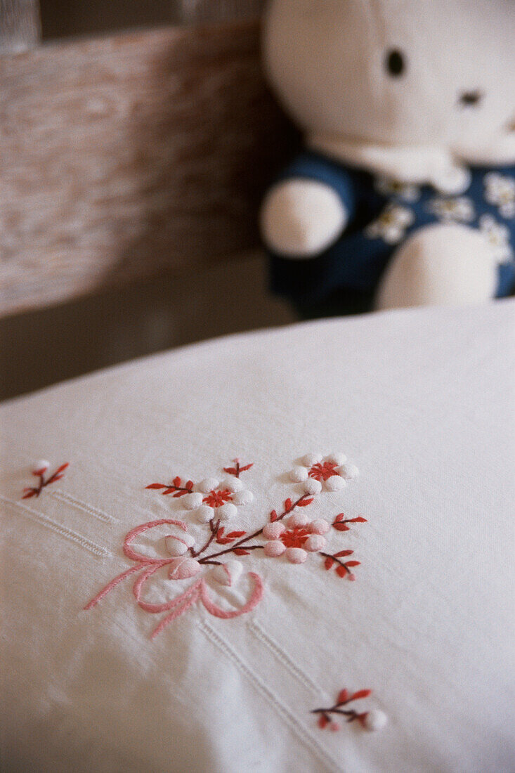 Detail einer Stickerei auf dem Kissen eines Kinderbettes