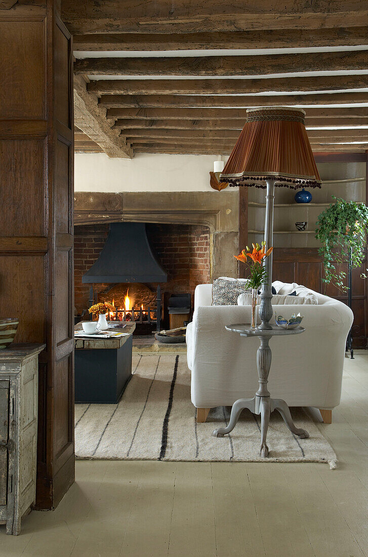 Weißes Sofa in Hastings Cottage mit Holzbalken und offenem Kamin