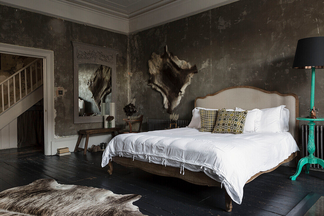 Tierfelle mit Vintage-Bett in einem unverputzten Schlafzimmer in Somerset, UK