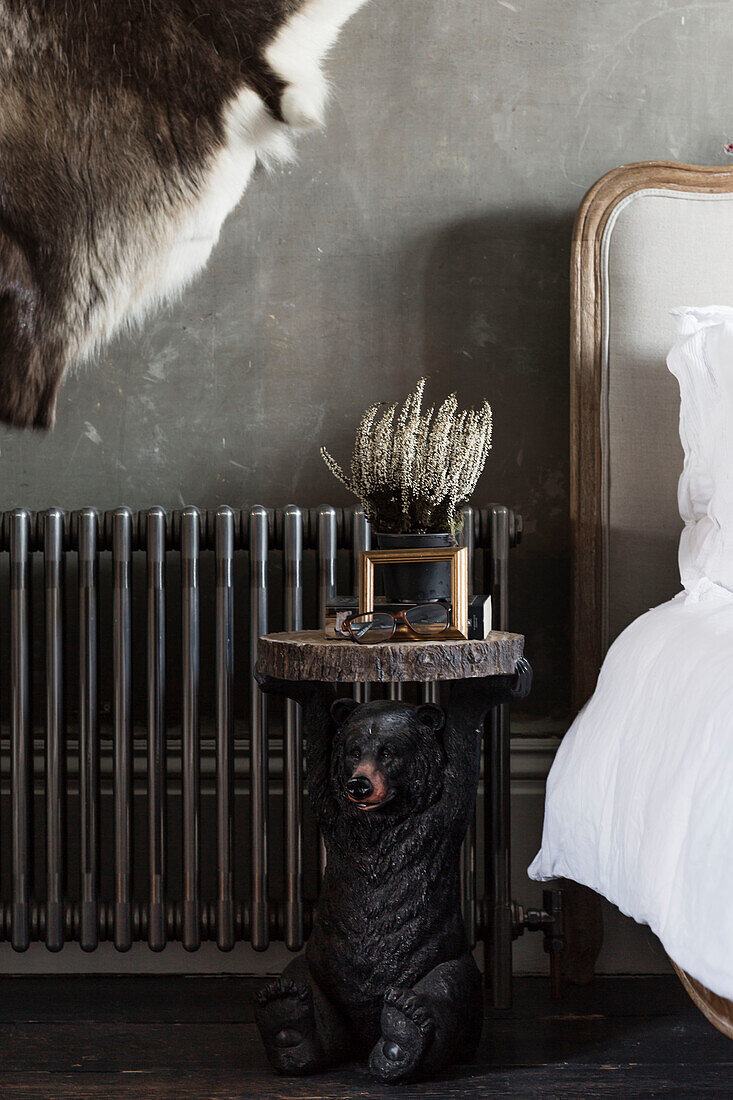 Antiker Beistelltisch in Form eines Bären mit Heizkörper am Bett in einem Haus in Somerset, UK