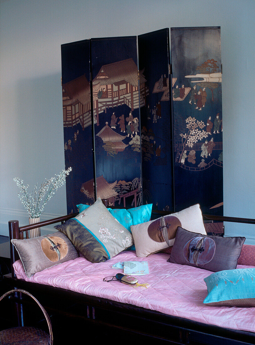 Orientalisches Zimmerset mit chinesisch bemaltem Paravent und chinesischem Tagesbett mit Streukissen in Blau, Rosa und Braun
