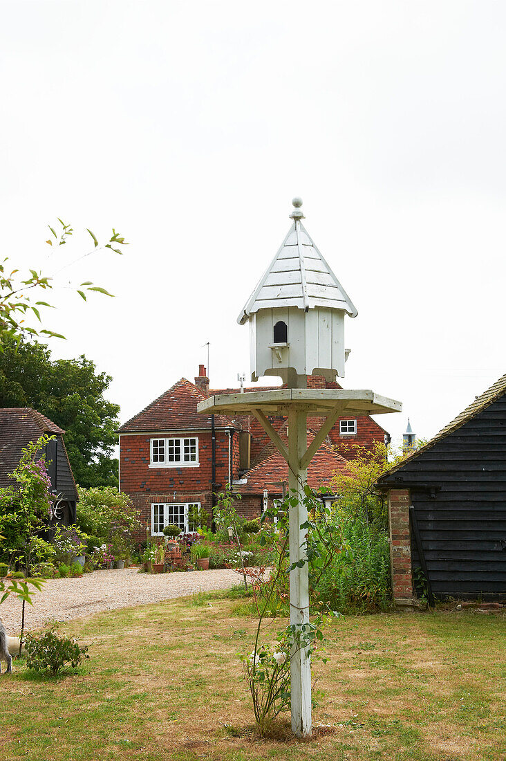 Weiß gestrichenes Vogelhaus im Garten eines Hauses in Iden, Rye, East Sussex, UK