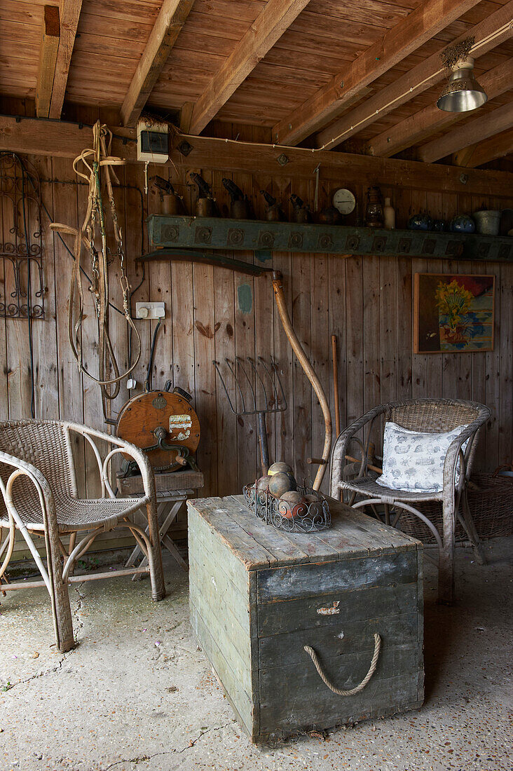 Crate and chairs in garden room of Iden farmhouse, Rye, East Sussex, UK