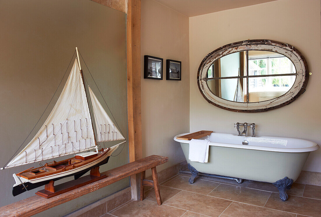 Freestanding bath and model boat with salvaged mirror in Iden farmhouse, Rye, East Sussex, UK