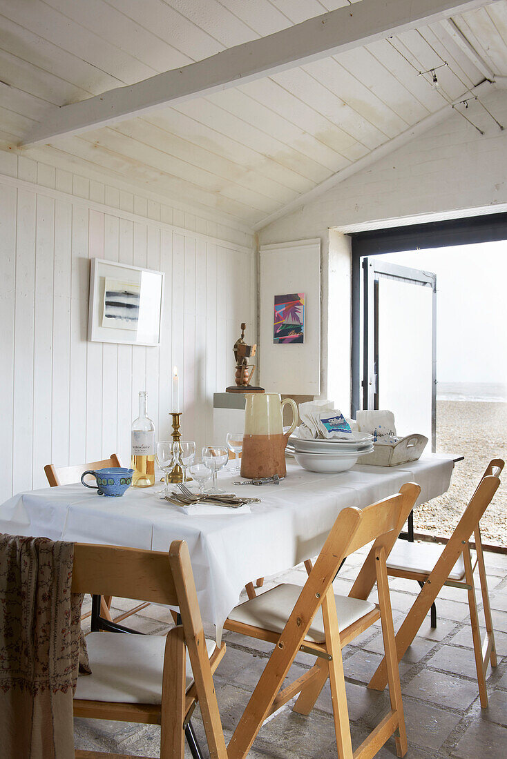 Esstisch mit Klappstühlen in einem Strandhaus in Aldeburgh, Suffolk, England, UK