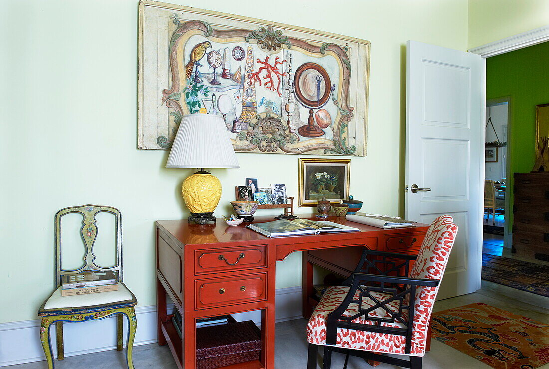 Stühle und Kunstwerke mit rotem Schreibtisch im Arbeitszimmer eines Hauses in Massachusetts, New England, USA