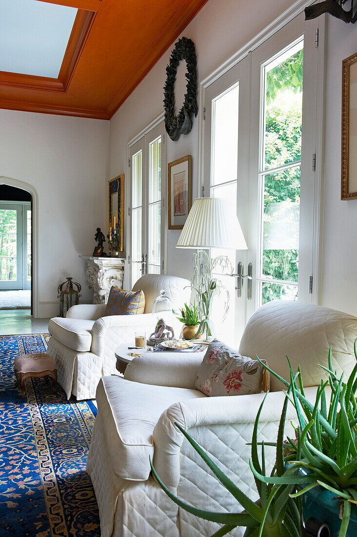 Weiße gepolsterte Sessel an Terrassentüren in einem Haus in Massachusetts, New England, USA