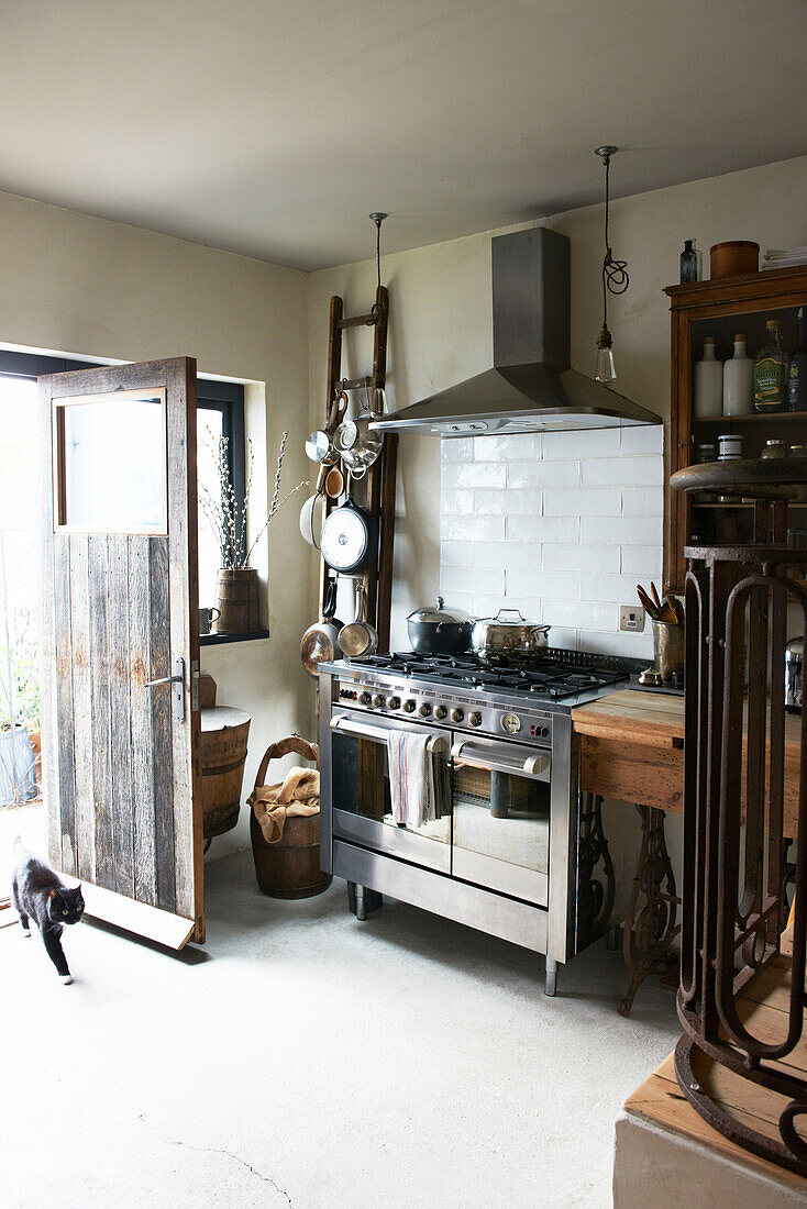 Stainless steel oven at open back door in Hastings home, East Sussex, England, UK