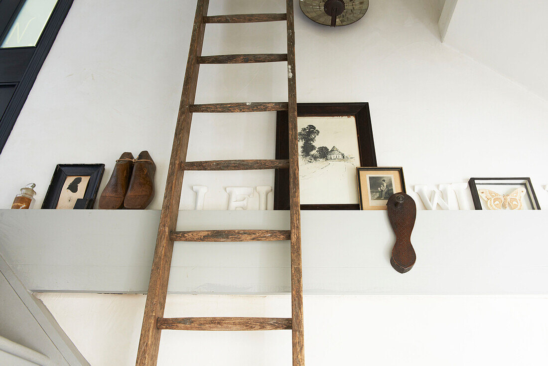 Wooden ladder with ornaments in staircase of Hastings cottage, East Sussex, England, UK