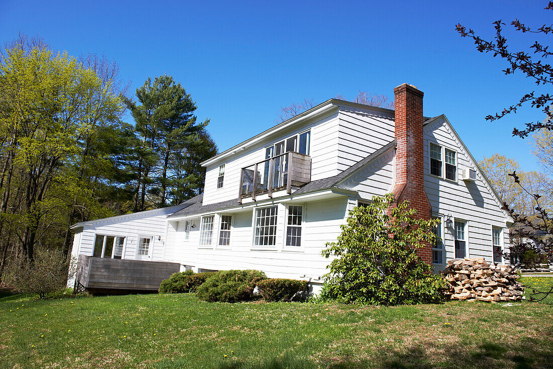 Weiße Fassade eines Einfamilienhauses mit Backsteinschornstein in den Berkshires, Massachusetts, Connecticut, USA