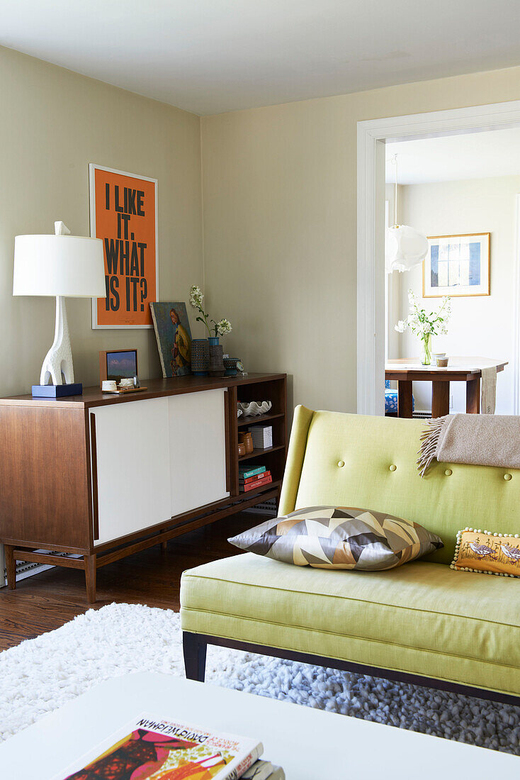 Gerahmtes Poster über hölzernem Sideboard mit lindgrünem Sofa in einem Wohnzimmer in den Berkshires, Massachusetts, Connecticut, USA