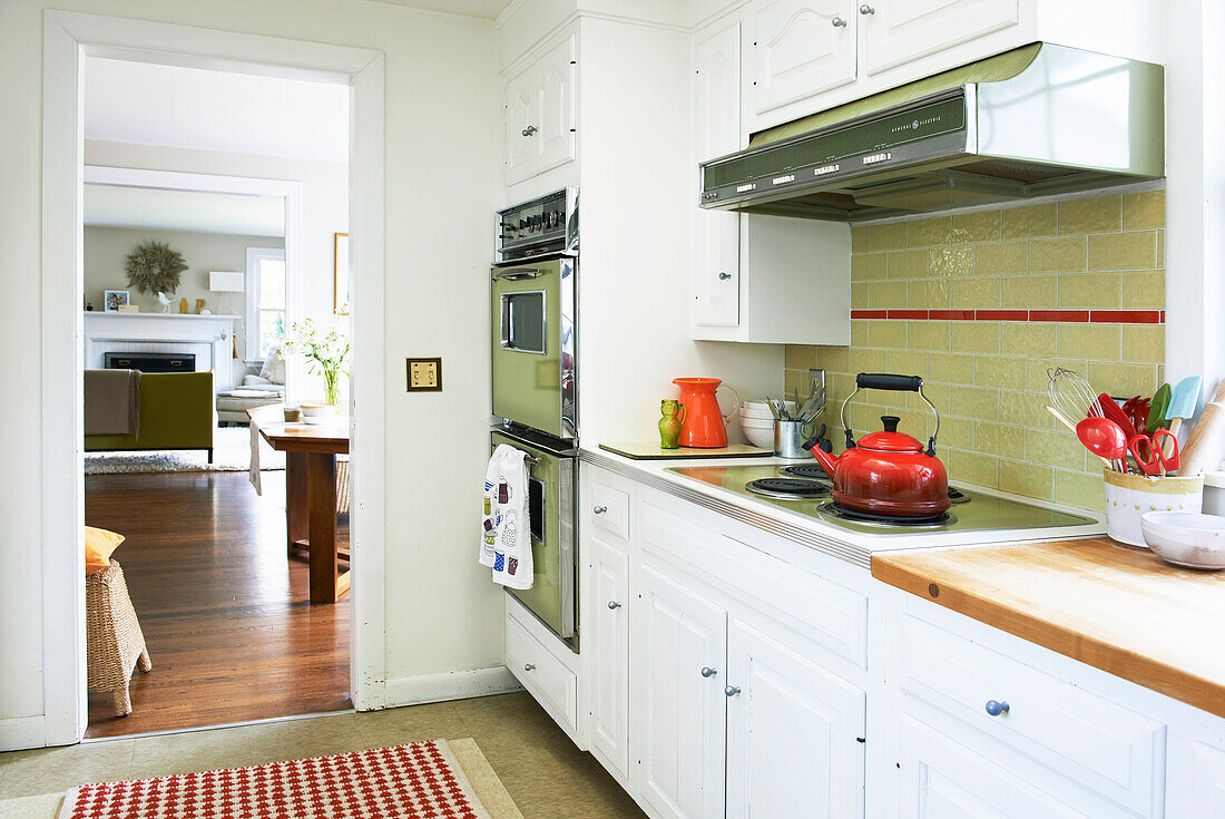 Roter Wasserkocher mit elektrischem Kochfeld und integriertem Backofen in der Küche eines Hauses in den Berkshires, Massachusetts, Connecticut, USA