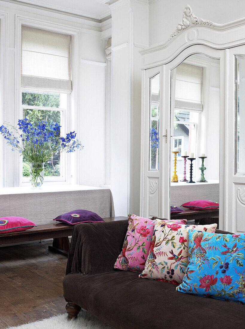 Mirrored wardrobe in living room with floral cushions in Hereford, England, UK