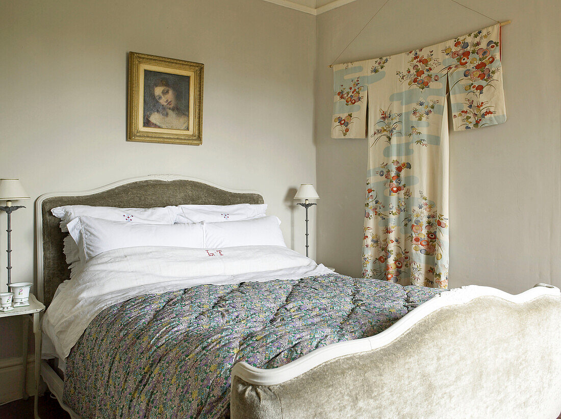 Kimono an der Wand eines Schlafzimmers mit gepolsterten Kopf- und Fußteilen auf dem Bett in einem Haus in Hereford, England, UK