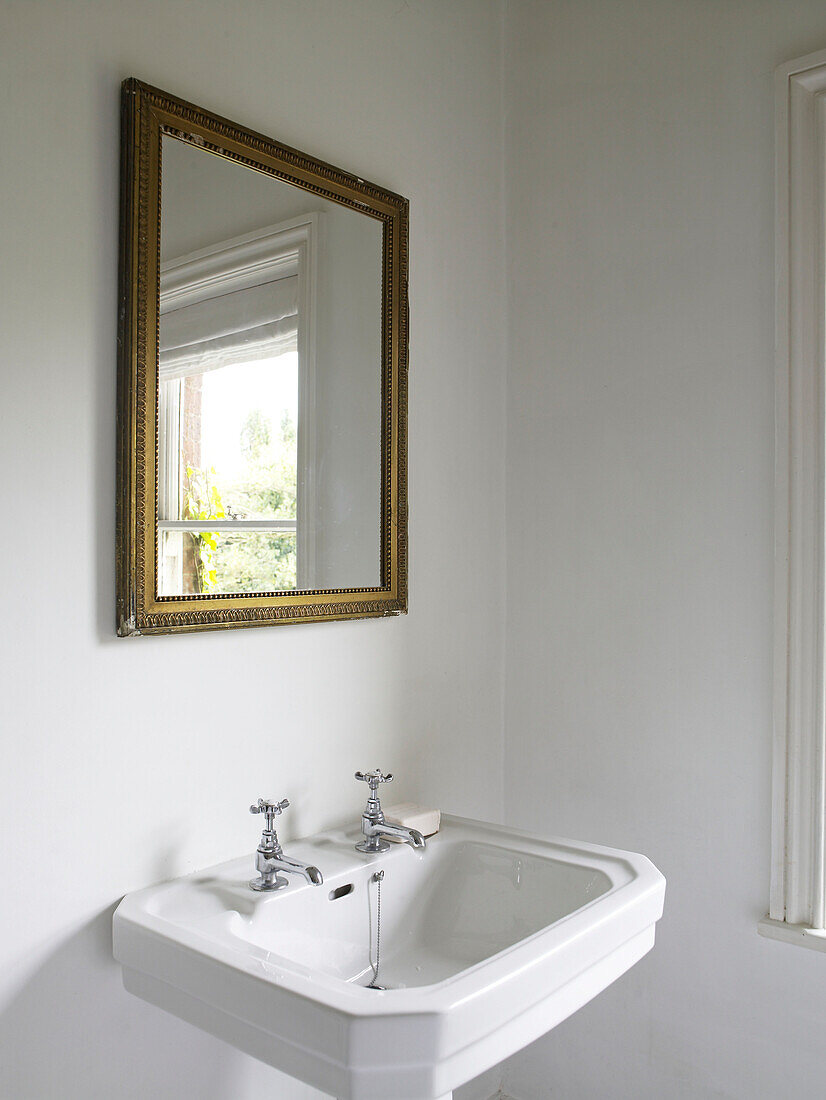 Gilt framed mirror above pedestal base wash stand in Hereford home, England, UK