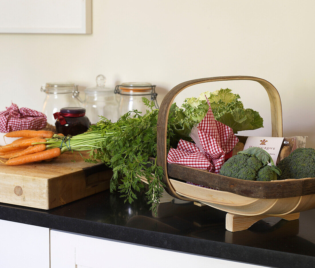 Vegetables and Christmas hamper on a kitchen worktop