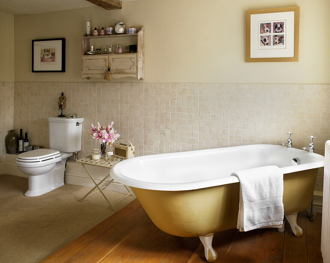 Freistehende Badewanne in einem teilweise gefliesten Badezimmer in einem Bauernhaus in Gloucestershire, England, UK