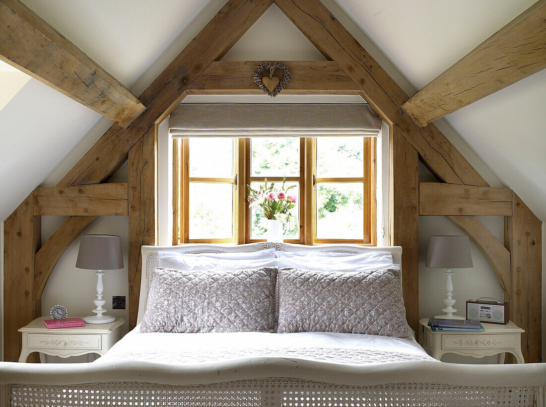 Bett am Fenster im Dachgeschoss eines Cottages in Gloucestershire England UK