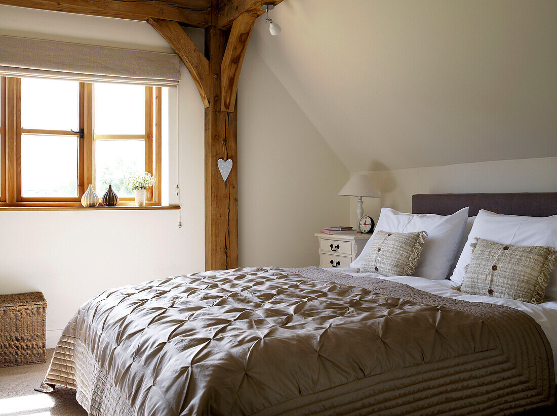Gesteppter Bettbezug in einem sonnenbeschienenen Fachwerkschlafzimmer in einem Cottage in Gloucestershire, England UK