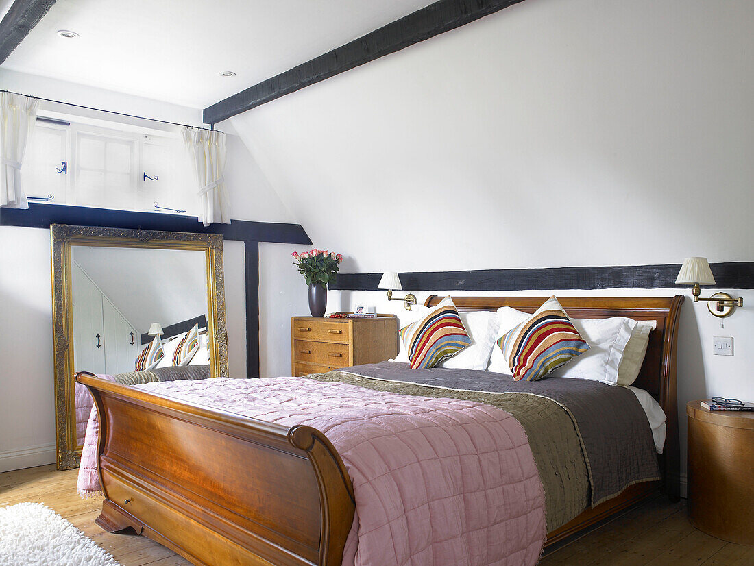 Antique polished wooden bed in timber-framed Buckinghamshire cottage England UK