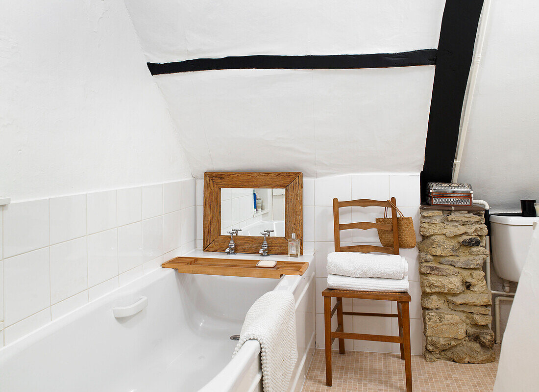 Exposed stone shelving and mirror in bathroom of timber-framed Buckinghamshire cottage England UK