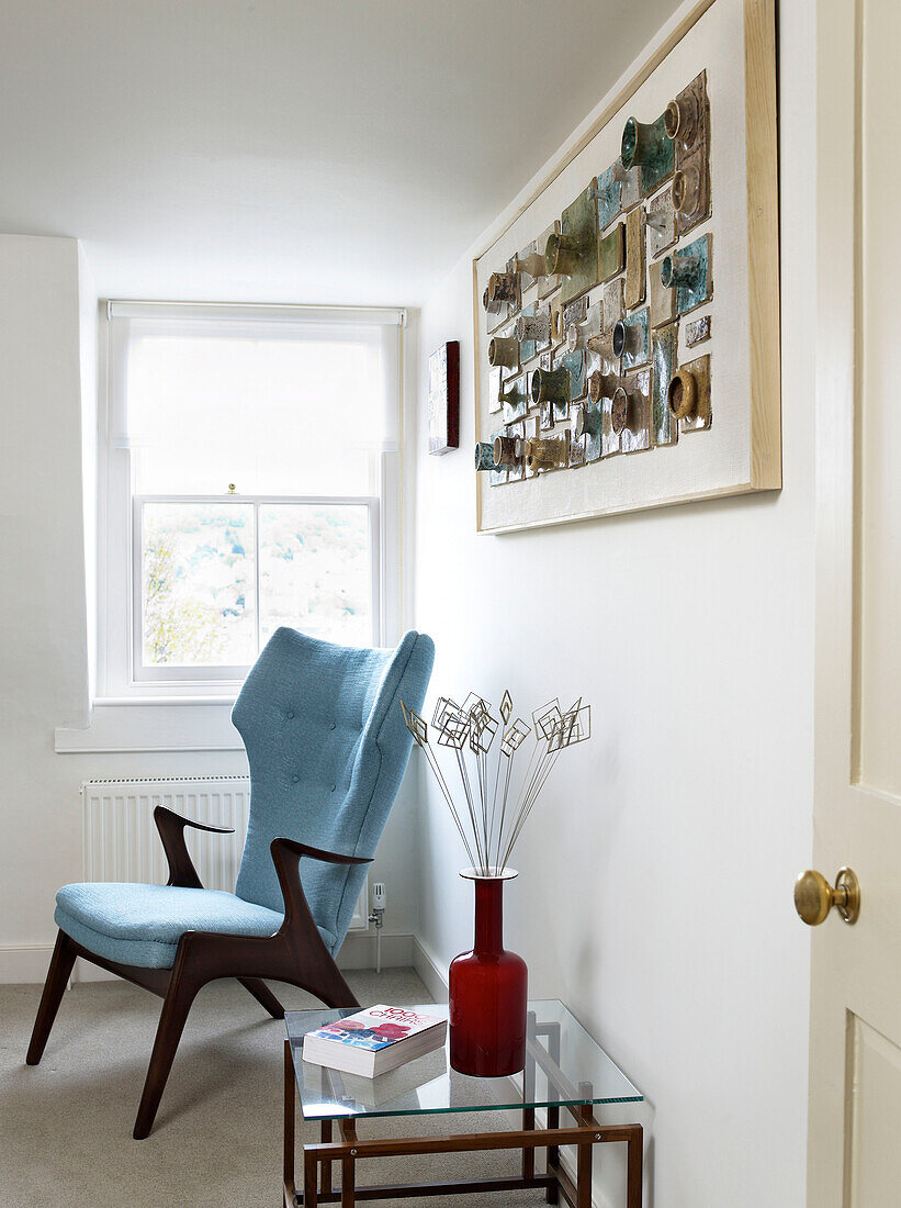 Vintage-Sessel mit Töpferkunst und Beistelltisch in einem modernen Haus in Bath, Somerset, England UK