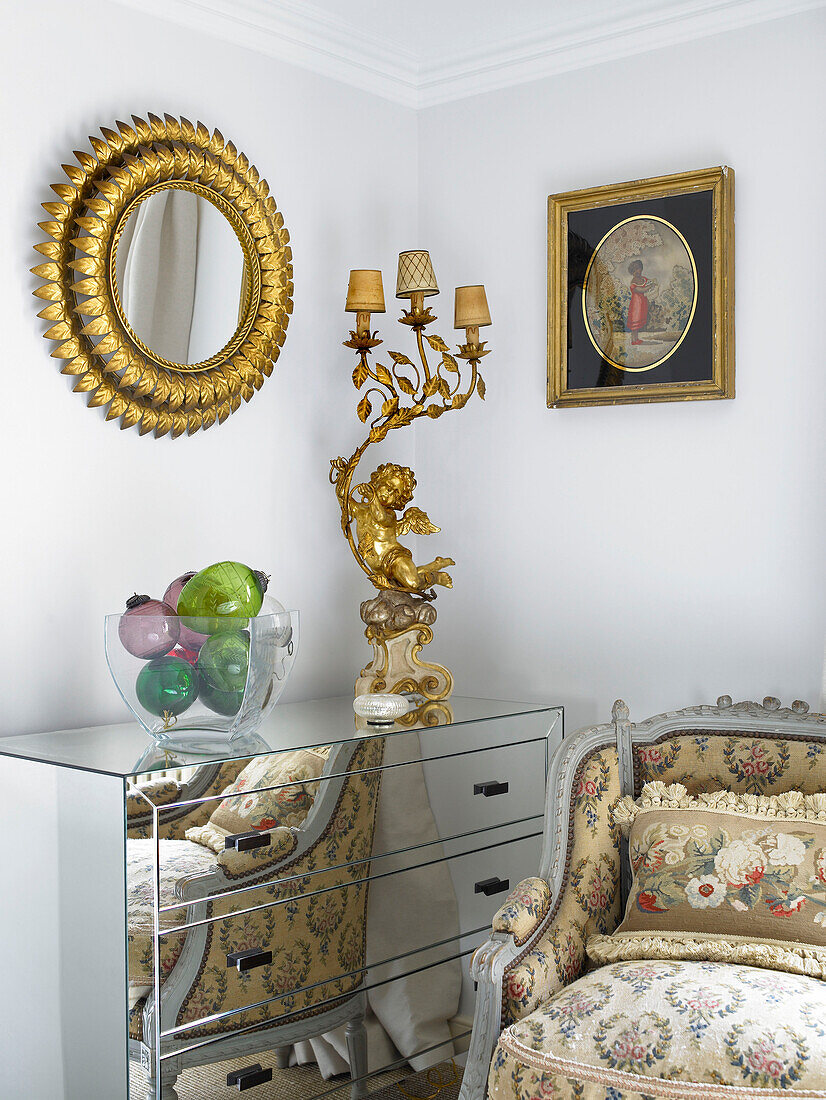 Blattgold-Spiegelrahmen und Lampe auf Spiegeltruhe mit Sessel in Zimmerecke Stadt Bath Somerset, England, UK