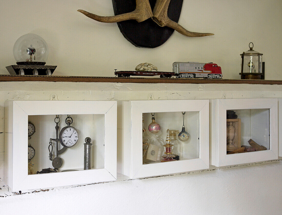 Sammlerstücke in einer Antiquitätenvitrine in einem Landhaus in Suffolk, England, UK
