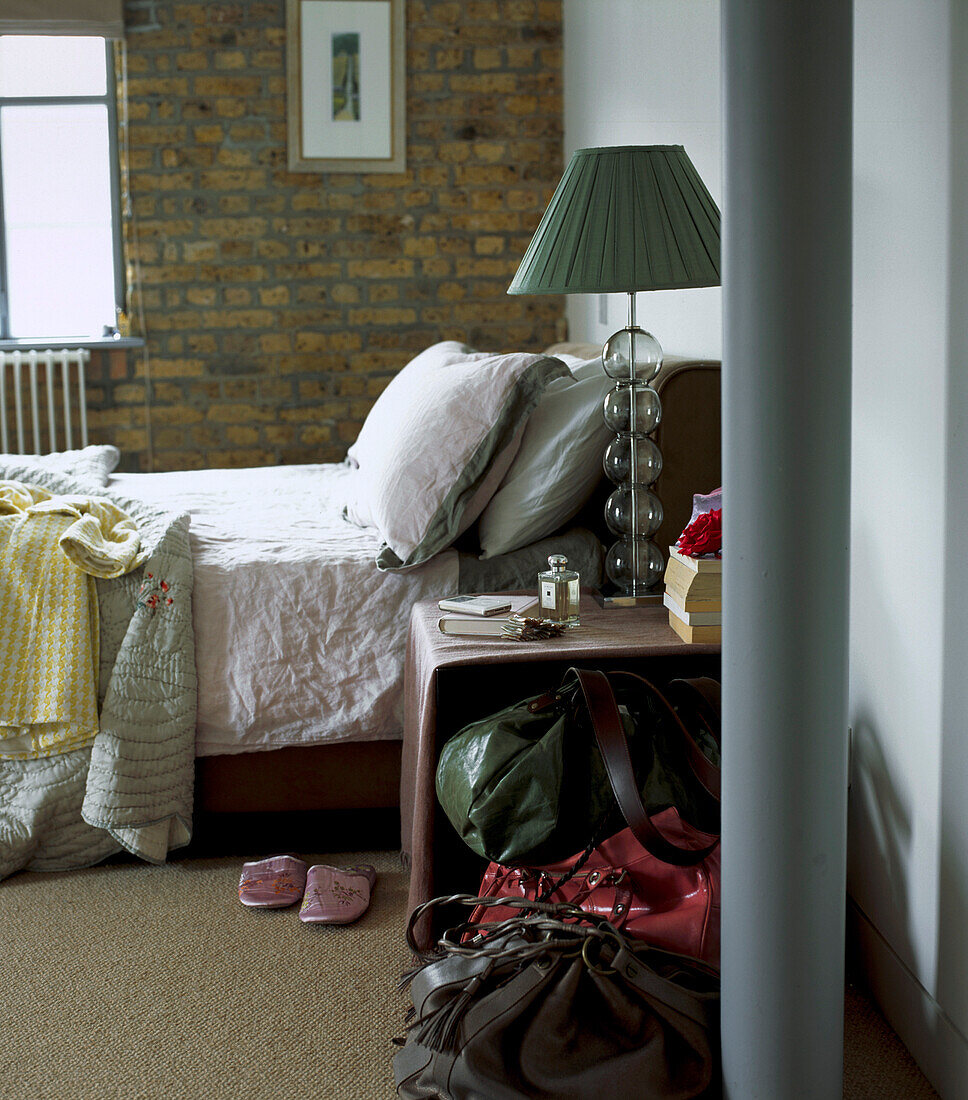 Schlafzimmer in einem umgebauten Lagerhaus mit ungemachtem Doppelbett