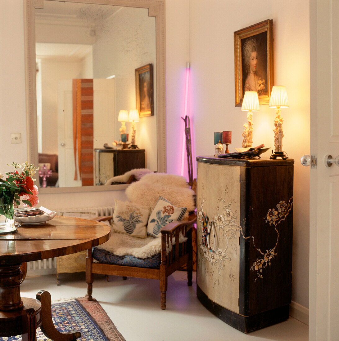 Modernes Wohnzimmer mit orientalischen Möbeln, großem Spiegel und eingeschaltetem Licht