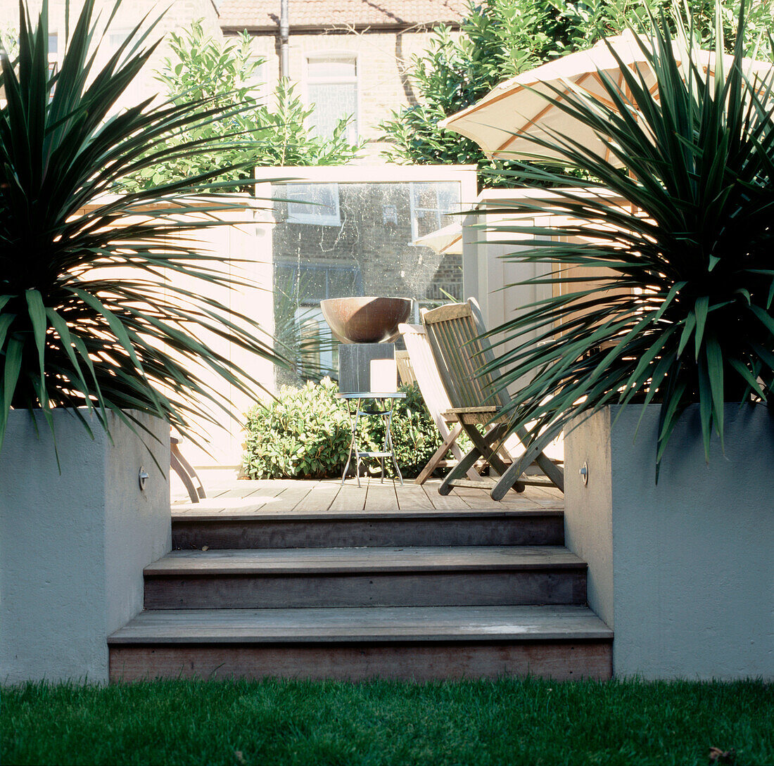 Holztreppe, die zu einem modernen, überdachten Gartenzimmer führt