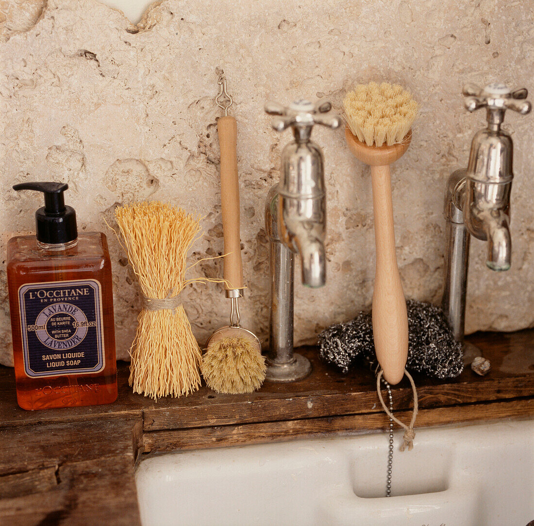 Kitchen sink and taps with washing up brushes and soap