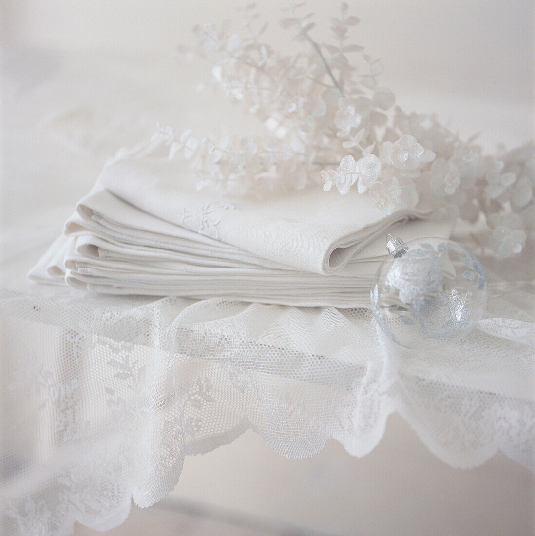 Tabletop detail with white delicate Christmas decorations