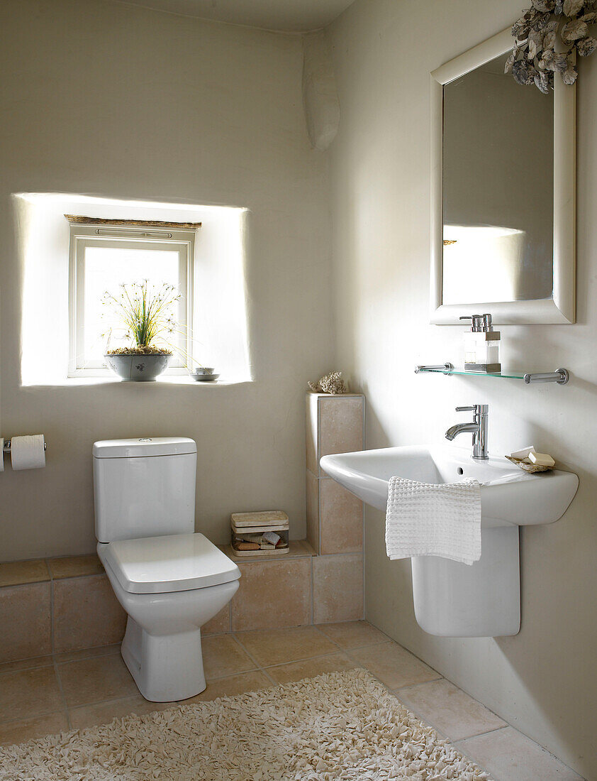 Sonnendurchflutetes weißes Badezimmer in einem Haus in Gloucestershire, England, UK