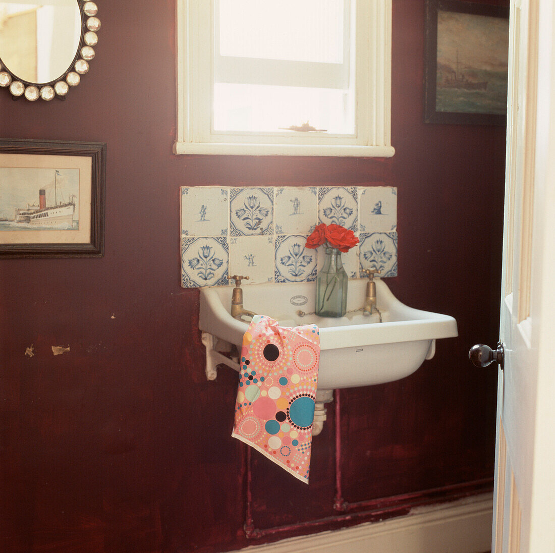 Waschraum im Erdgeschoss mit altem Waschbecken, gefliestem Spritzschutz und dunkelviolett gestrichenen Wänden