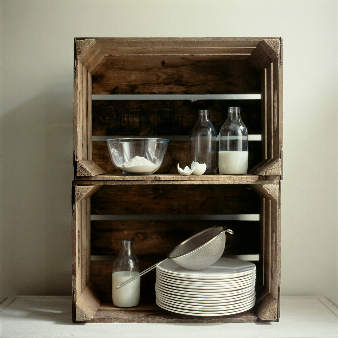 Make shift storage units from old wooden crates containing kitchenware