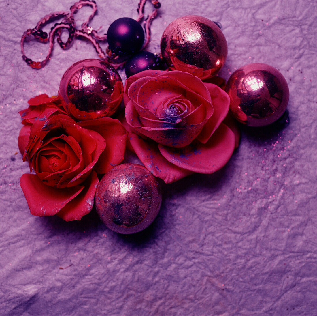 Weihnachtsdekoration mit roten und rosa Blumen und Kugeln