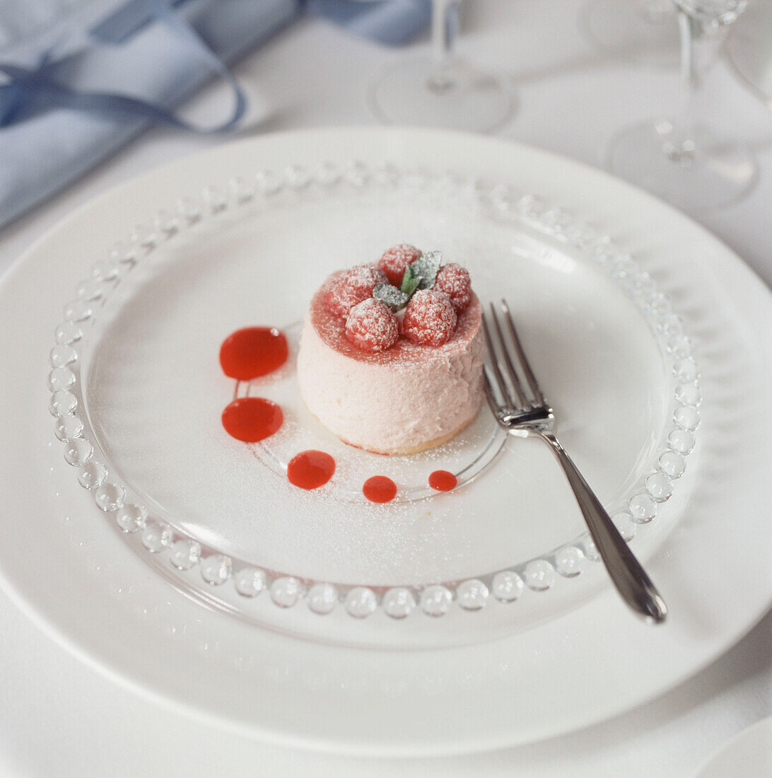 Himbeer-Mousse-Dessert auf einem weißen Teller