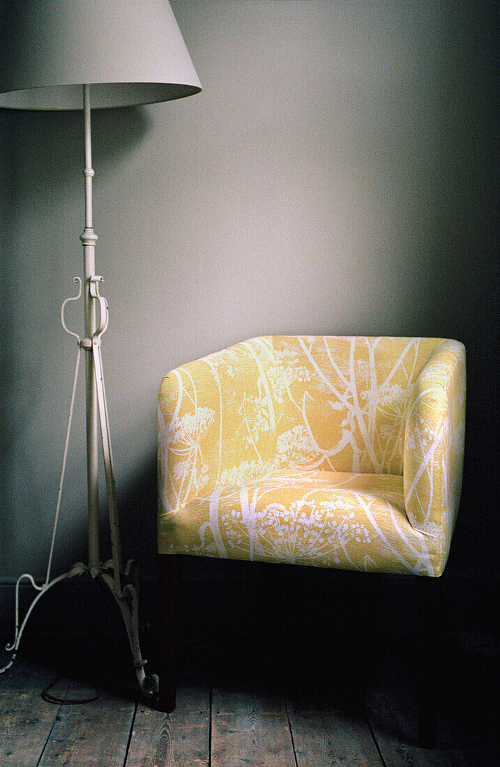 Wohnzimmer mit gepolstertem Sessel und Stehlampe