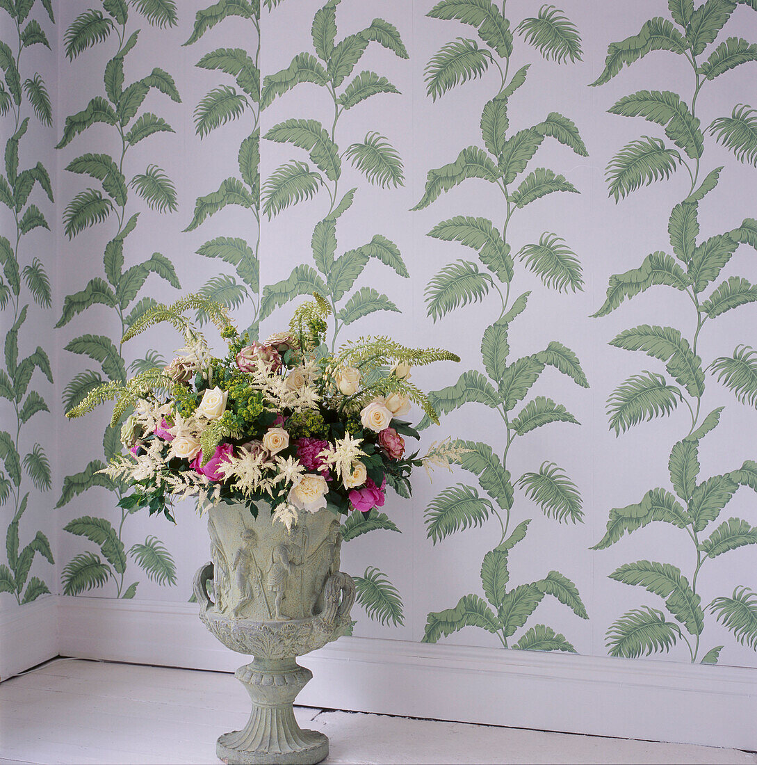 Grün gemusterte Tapete 'Paradise' von Julien Mcdonald und eine Steinurne mit Blumenschmuck