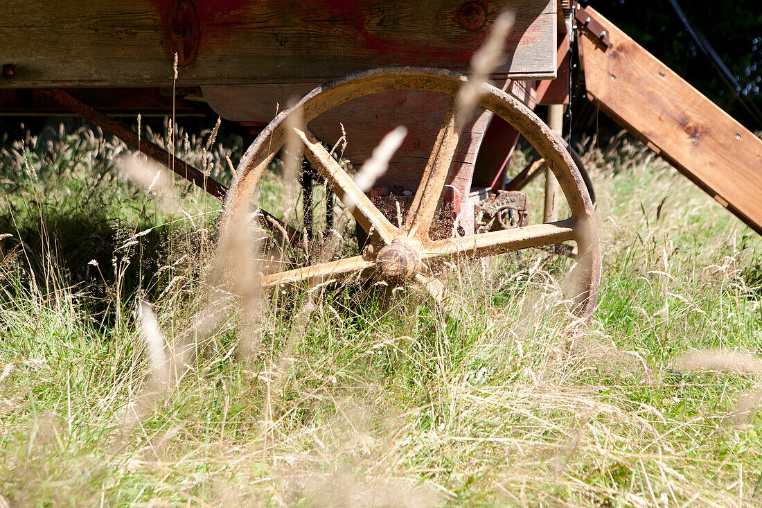 Rusty iron wheels of a Shepherds hut in a summer meadow