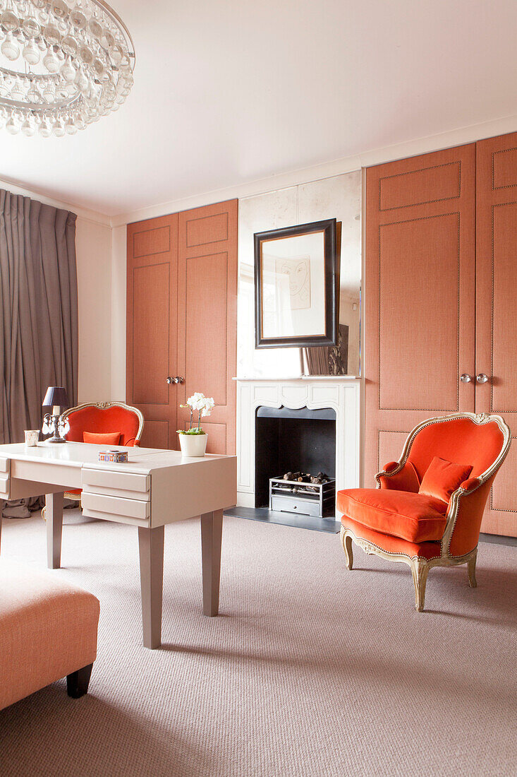 Zwei gepolsterte Sessel und ein Schreibtisch in einem modernen Londoner Haus England UK